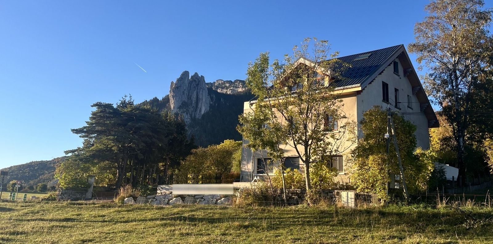 Le gîte Hä-elto au soleil d'automne, avec les Trois Pucelles qui se dressent juste derrière